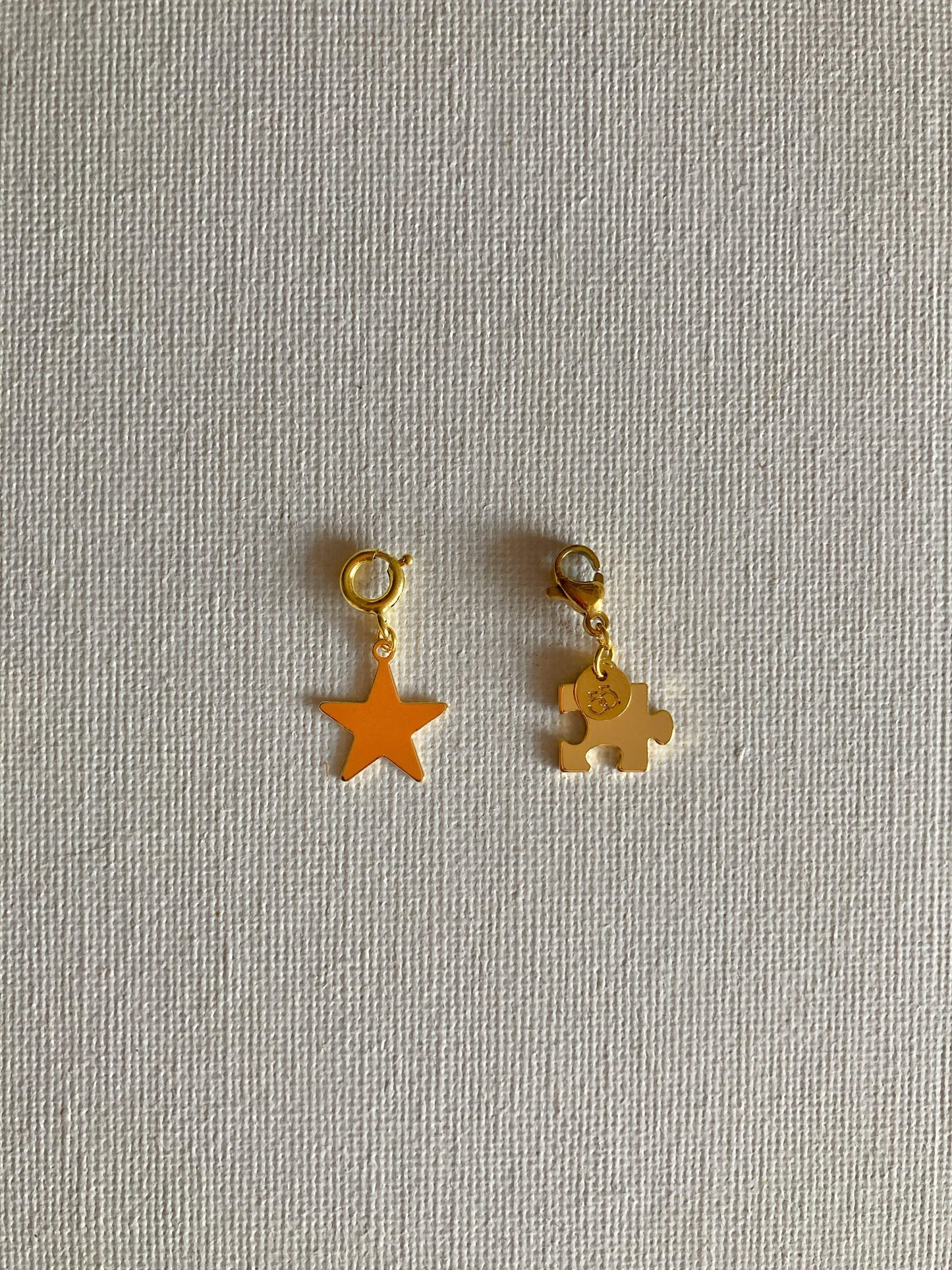 Stellina e Puzzle, piccoli particolari che fanno la differenza! in ottone dorato ed il loro moschettone che li rende versatili: puoi agganciarli dove vuoi tu!