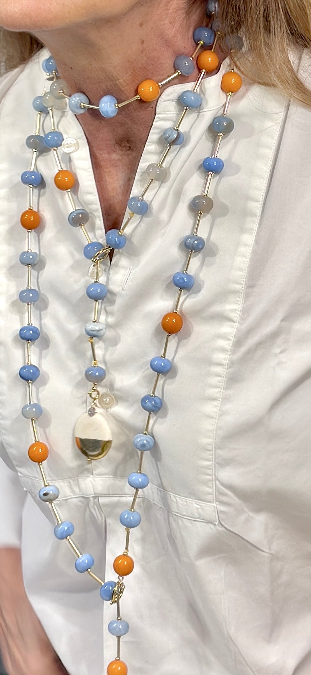 Collana Rainbow Candy indossata su camicia bianca - qui le collane sono 2 entrambe indossate a Cravatta, lunga e corta. E la corta ha anche un ON|OFF, i ciondoli che metti dove vuoi tu, in osso e foglia d’oro.